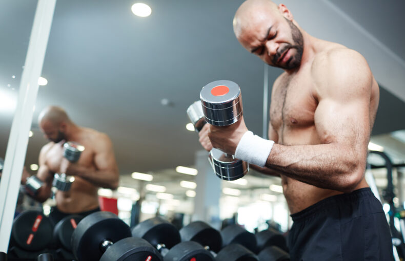 Shirtless Man Lifting Weights During a Gym Workout