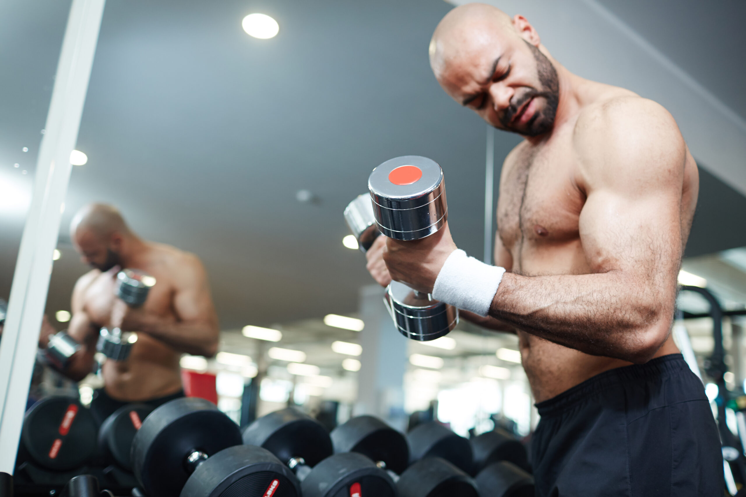 Shirtless Man Lifting Weights During a Gym Workout